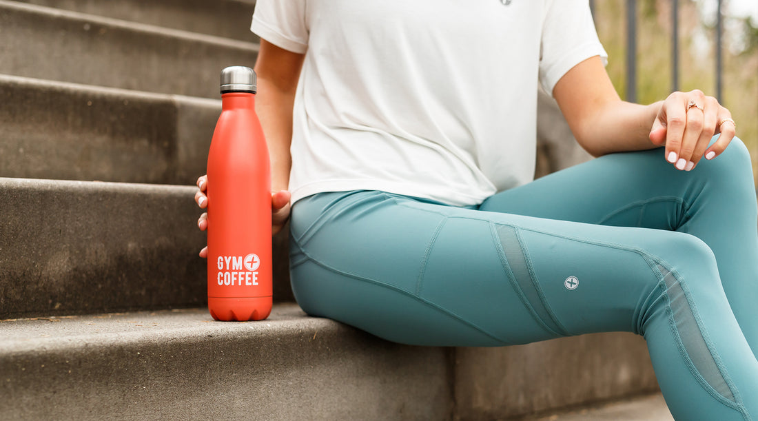 Woman in Gym+Coffee leggings with a sustainable stainless steel water bottle.